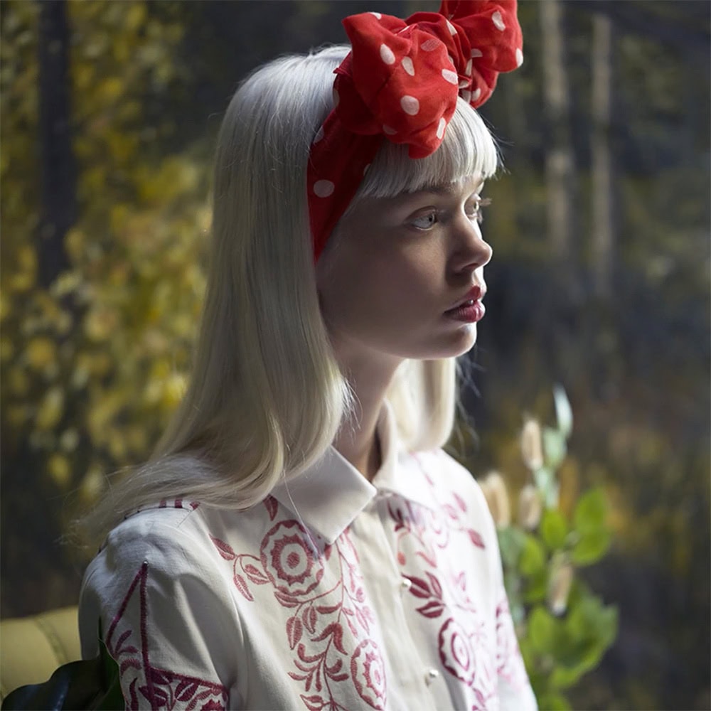 JF Peace design at Green Little Heart, a girl in an arty forest environment with a brodery remade shirt in white and red.