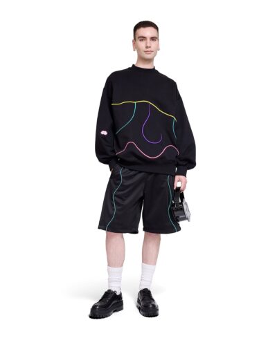 Svart sweatshirt med gula, turkosa, lila och rosa linjer som visar ett ansikte.